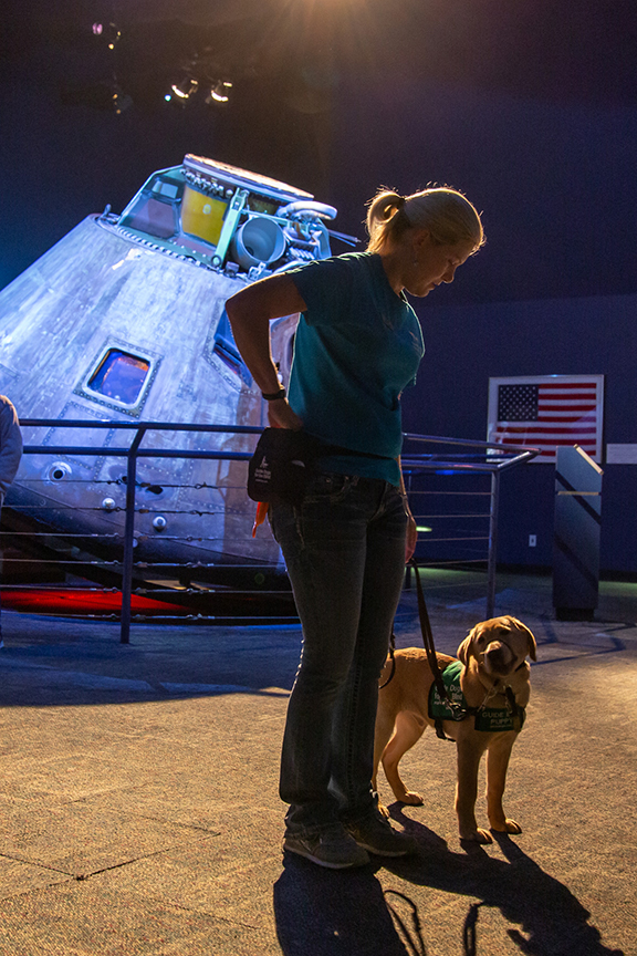 Visitor walks guide dog past Apollo 17 command module
