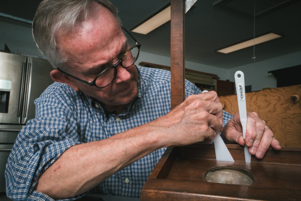 Conservator Steve Pine examines the lectern's desk clock features. / Photograph by Aaron Rodriguez